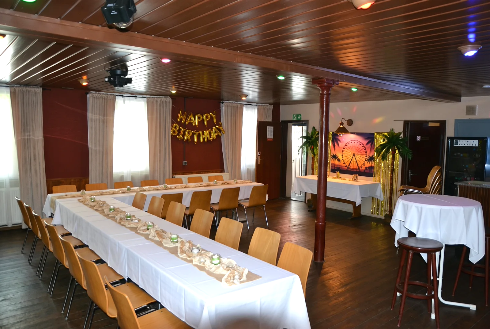 Partyraum mit langer Festtafel und Happy-Birthday-Deko